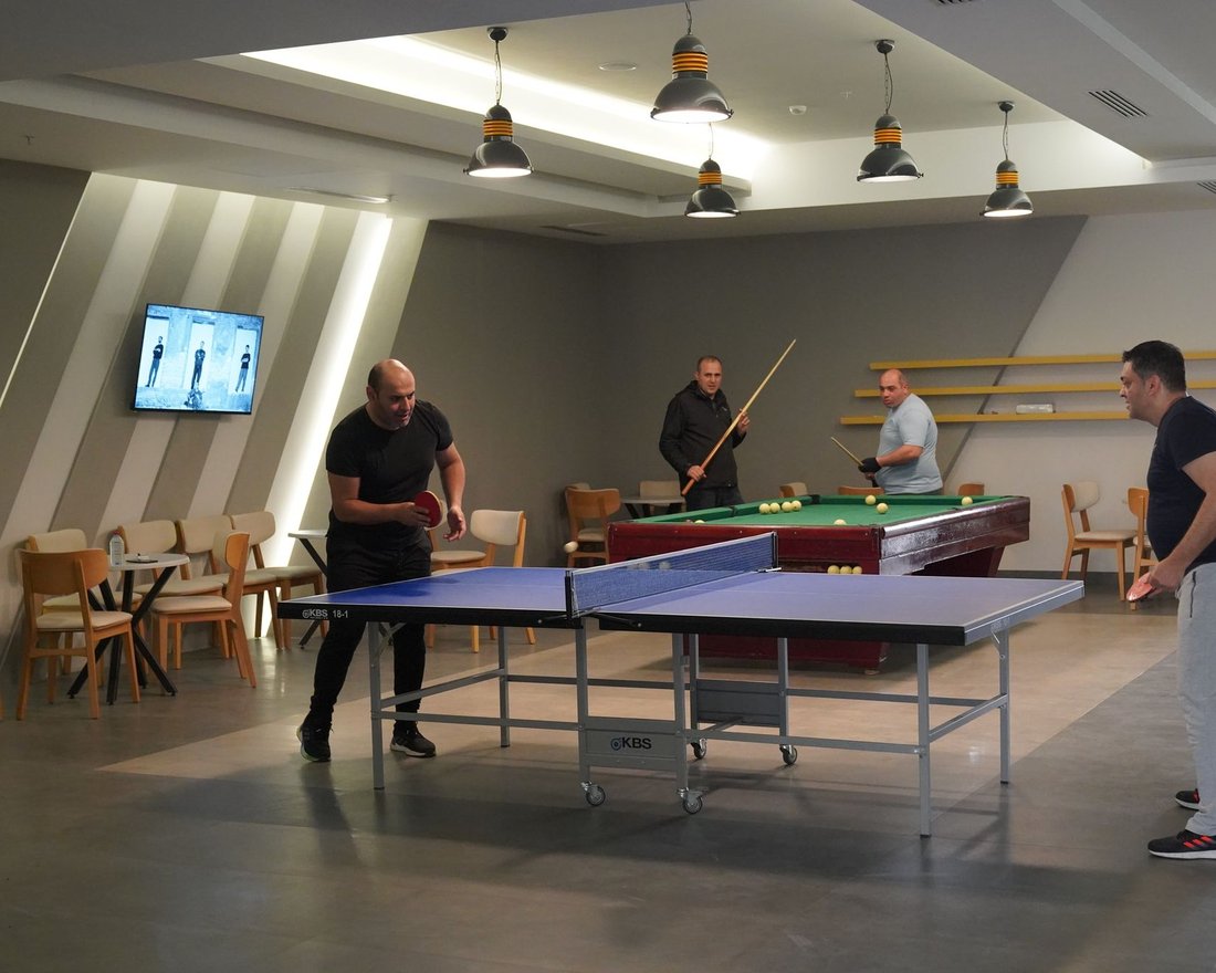 Clubhouse games room with a table tennis table, a pool table and seating for board games