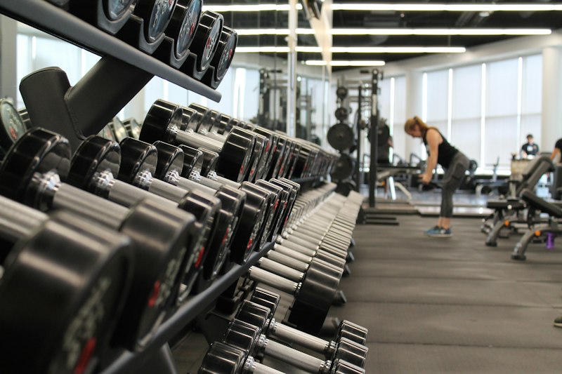 Gym with rows of dumbbells and training equipment